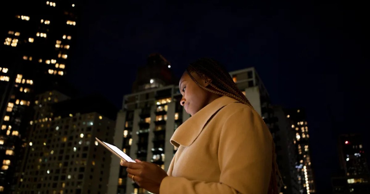 Someone checking a phone outdoors at night