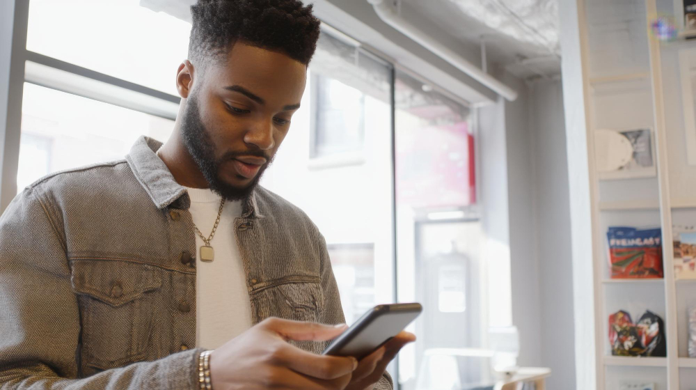 A man looking at his phone inside a retail store