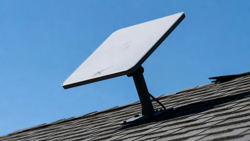 Close-up of a Starlink satellite internet dish mounted on a home roof against a clear sky