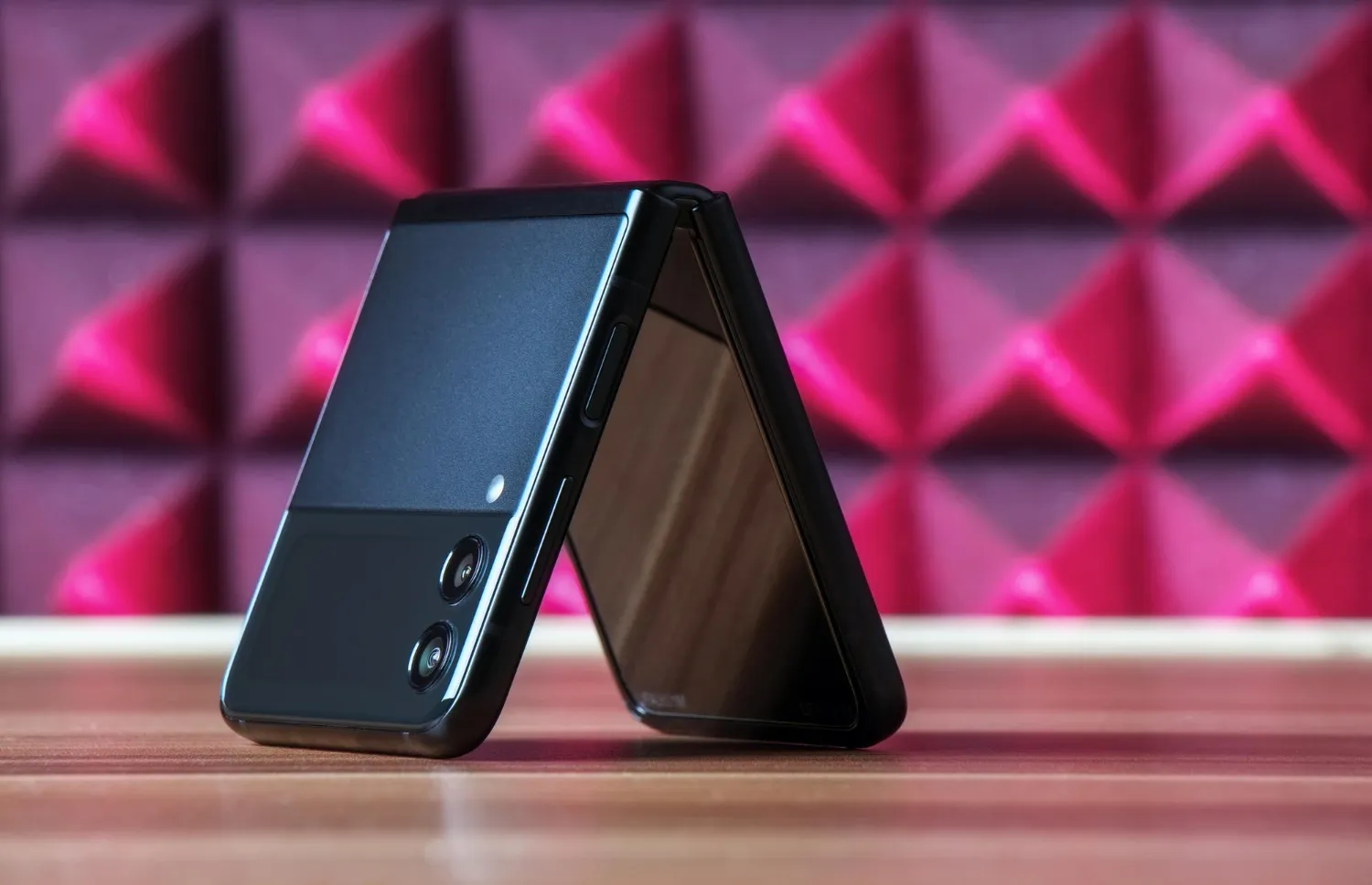 A clamshell foldable phone open beside a basic flip phone